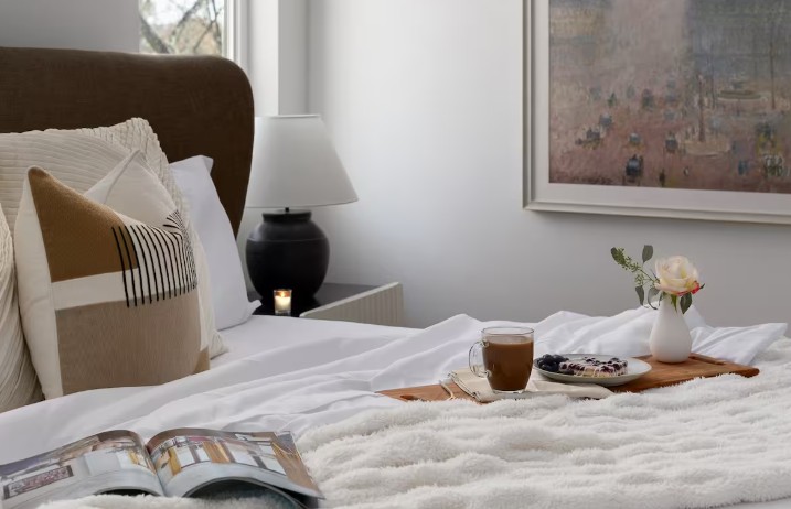 Photo of soft linens, warm coffee, and breakfast in bed at an Airbnb in Asheville.