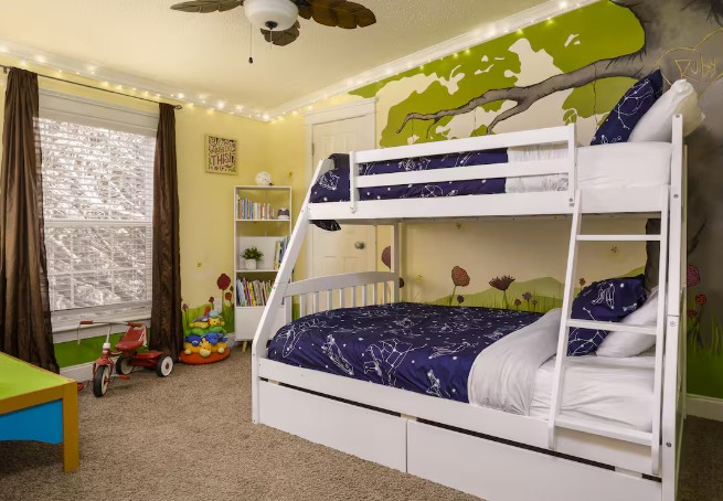 Children's bedroom with bunk beds, a shelf with books and toys.