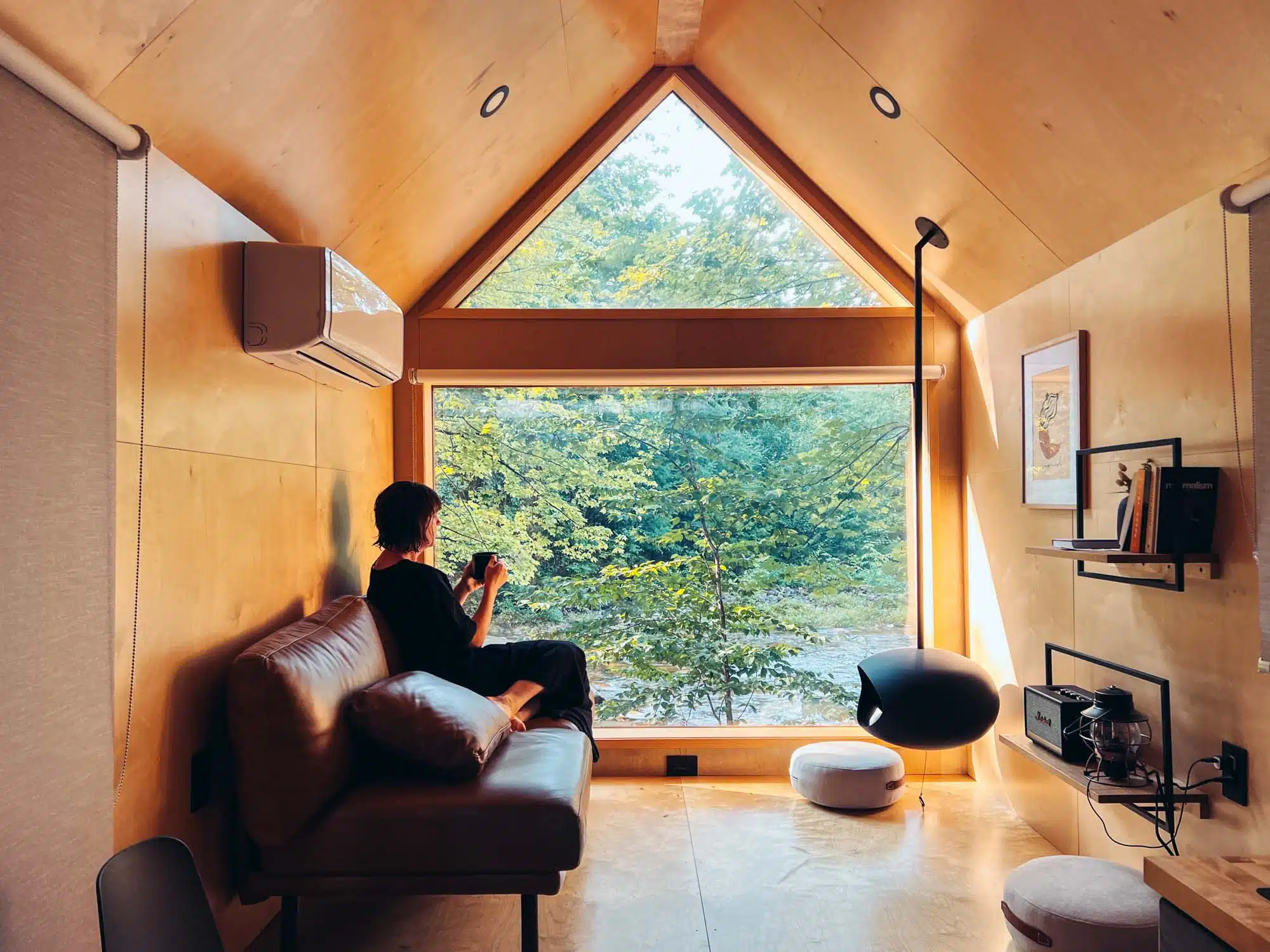 Victoria sat on the sofa enjoying the view at Lumen Nature Retreat