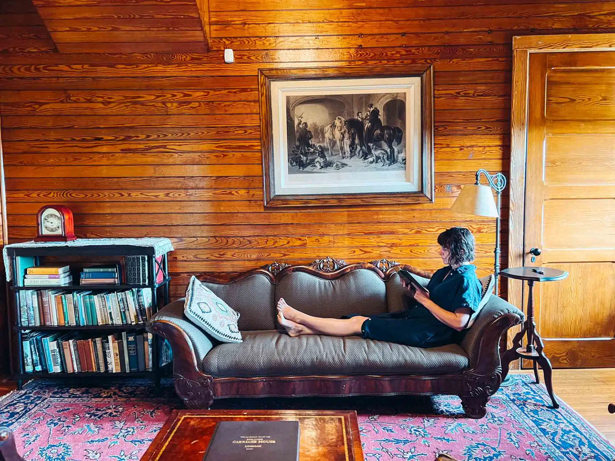 Victoria reading a book on the sofa at Kiplings Carriage House.